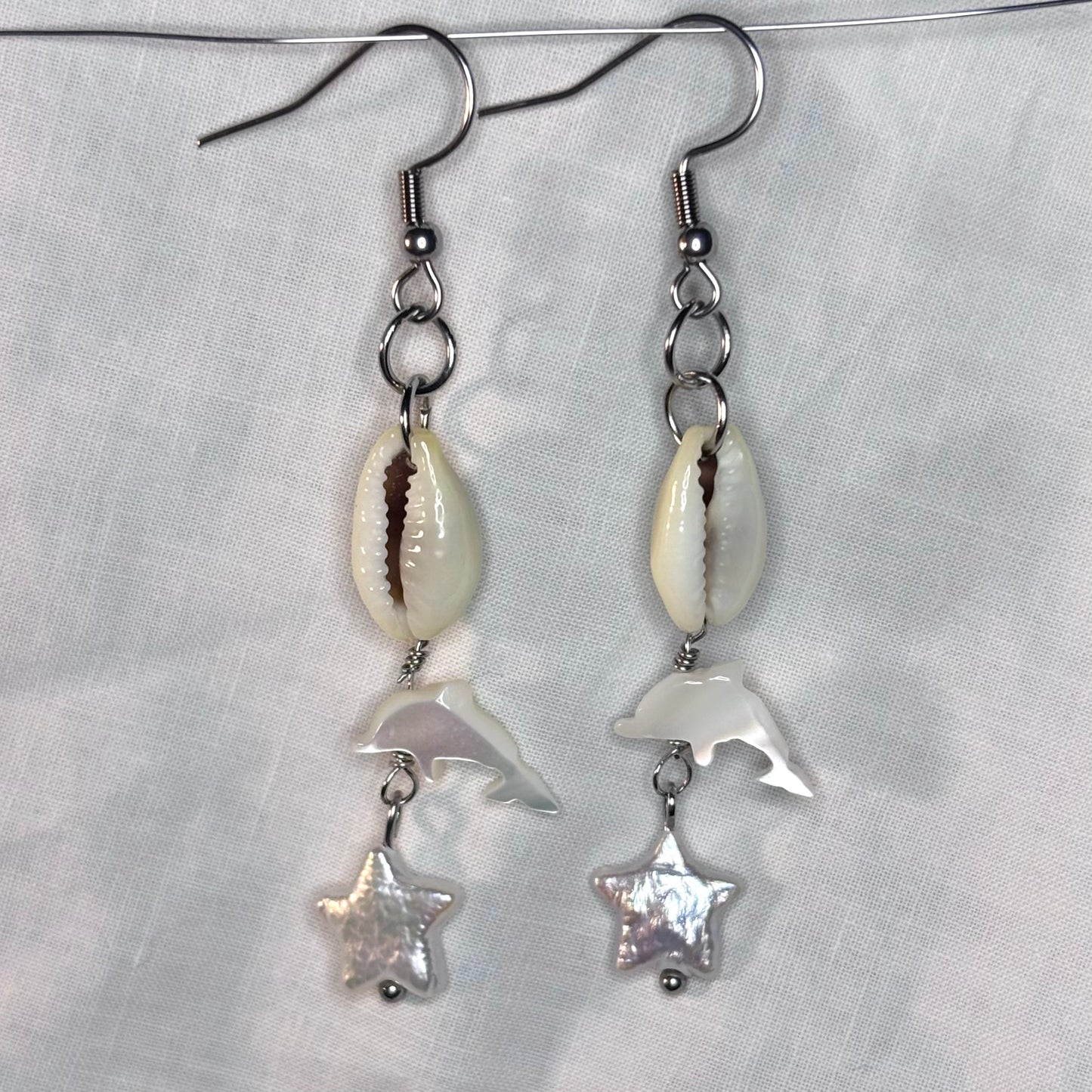 cowrie shell, pearl, and shell dolphin earrings